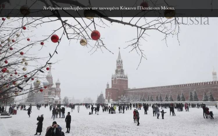 <p>Άνθρωποι απολαμβάνουν την χιονισμένη Κόκκινη Πλατεία στη Μόσχα.</p>